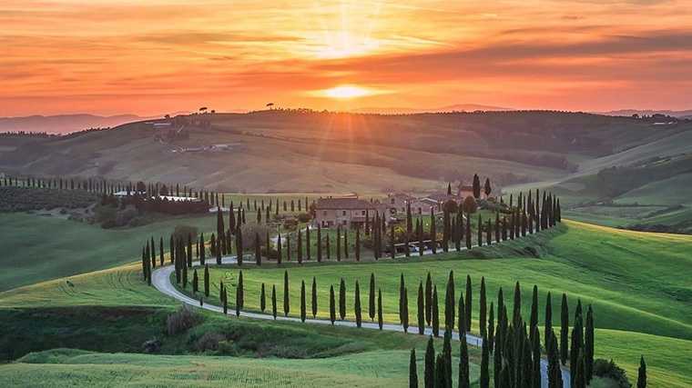 De typische kronkelweggetjes met cipressen in Val d’Orcia, Toscane.