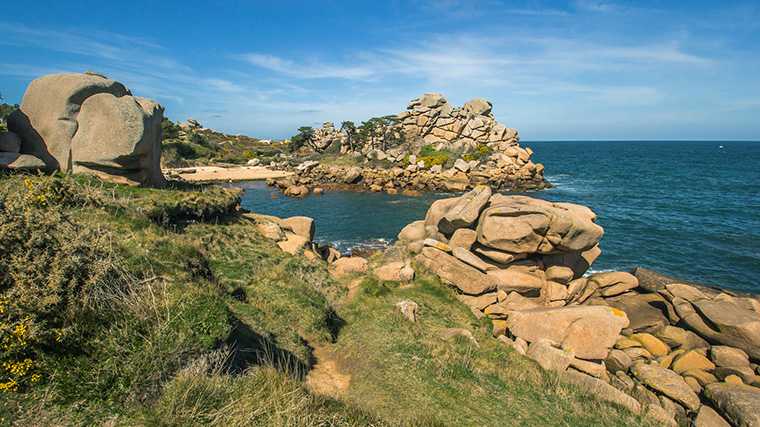 Tussen de vreemd gevormde rotsblokken aan de Côte de Granit Rose vind je talloze strandjes.