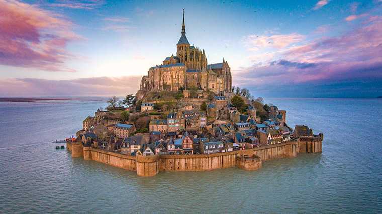 Afhankelijk van het getij wordt de abdij van Mont Saint-Michel omringd door water.