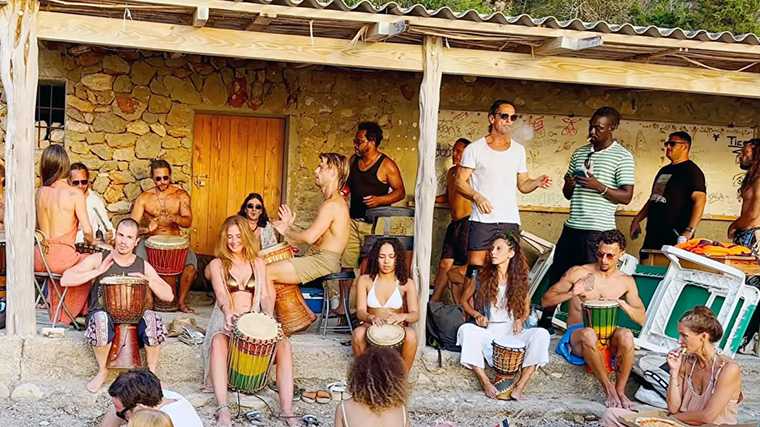 De drum circle in full swing op Cala Benirrás, Ibiza.
