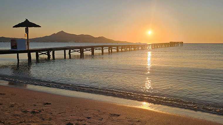 Vroege vogels rijden met de huurauto naar het strand van Alcúdia voor een mooie zonsopkomst.