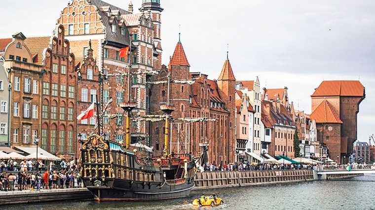 Una réplica de un barco medieval y la grúa histórica del puerto de Gdańsk.