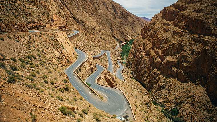 En voiture de location, tu remontes cette route sinueuse depuis l'oasis verdoyante de la vallée du Dadès.