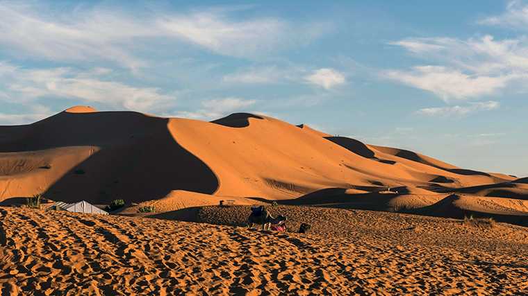Tu n'oublieras jamais ça : les dunes de sable orange d'Erg Chebbi au coucher du soleil.