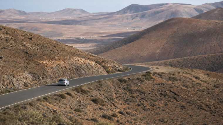 Kronkelende weg door de droge heuvels van het binnenland van Fuerteventura