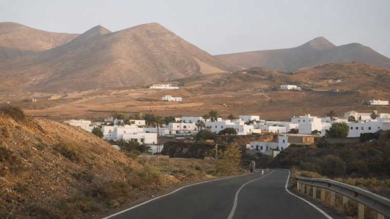 Een rustig dorp met witte huizen tussen vulkanische heuvels op Fuerteventura