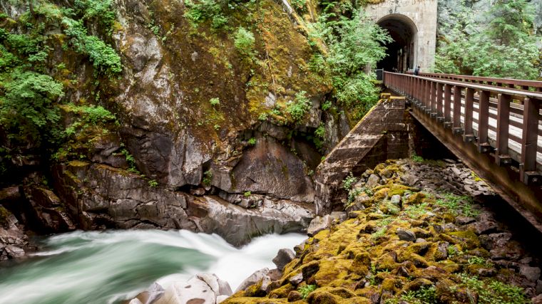 De voormalige spoorlijn loopt door verschillende tunnels en langs een snel stromende rivier.