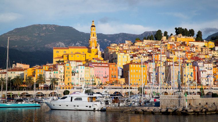 De kleurrijke huizen van Menton met prominent daarbovenuit de basiliek Saint-Michel Archange. (Foto: https://unsplash.com/@canmandawe)