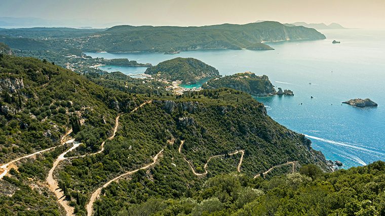 Het uitzicht vanaf het kasteel Angelokastro. De kleine rots in de baai van Palaiokastritsa (rechtsboven) is volgens de legende het versteende schip van Odysseus.