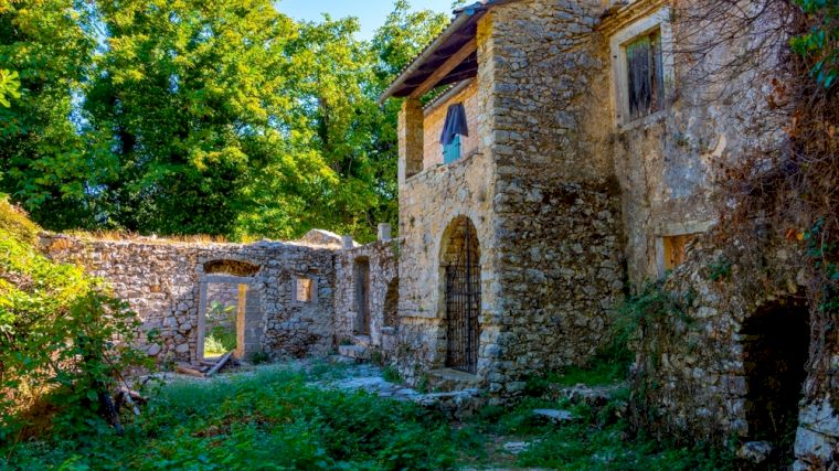 Verlaten huizen in het oude dorpje Peritheia op Corfu.