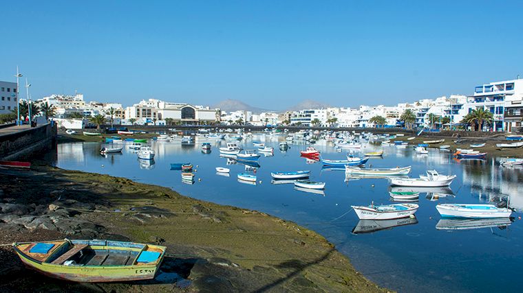 In de zoute lagune van Arrecife liggen vissersbootjes te dobberen.