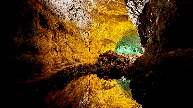 De weerspiegeling van de mooi verlichte Cueva de los Verdes.