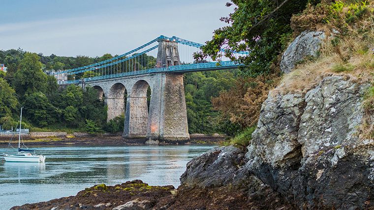 De iconische Menai Bridge is een van de twee bruggen die Anglesey met het vasteland verbindt.