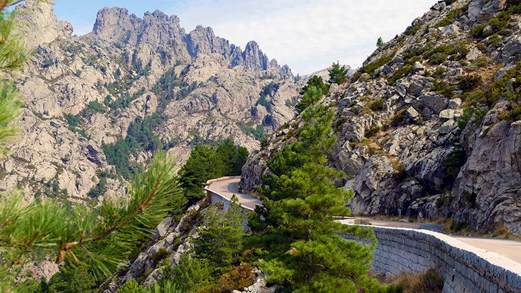 Rijd met je huurauto langs de steile, ruige rotsen van Aiguilles de Bavella op Corsica.