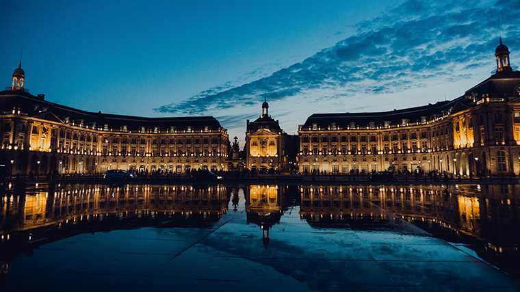 De weerspiegeling van de gebouwen op Place de la Bourse in het Miroir d&#8217;Eau.