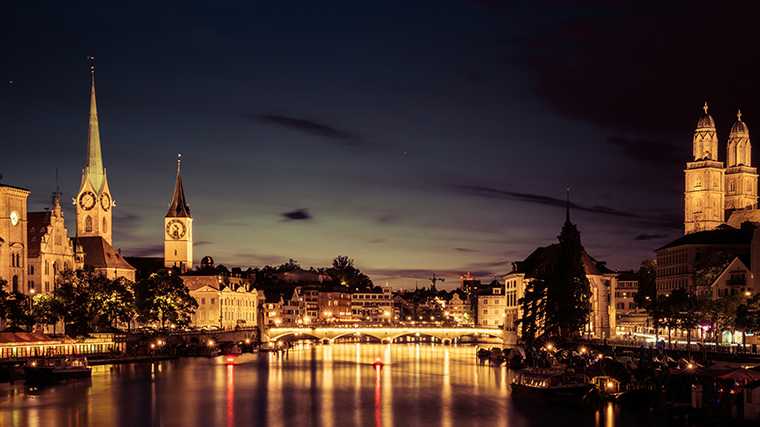 De oude monumenten van Zürich zijn ’s avonds fraai verlicht.
