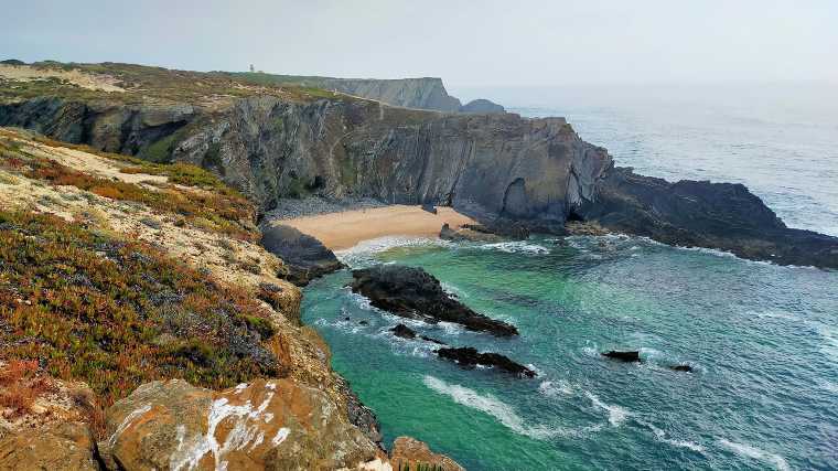 Veel strandjes aan de westkust van Portugal liggen tussen hoge kliffen.
