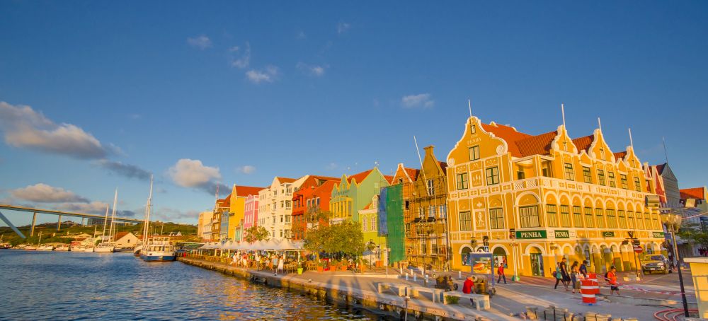 Kleurrijke huizen aan de Handelskade in Willemstad, met een deel van de Koningin Julianabrug